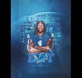 Detroit football player in a blue uniform posed with arms crossed in front of a blue stadium collage